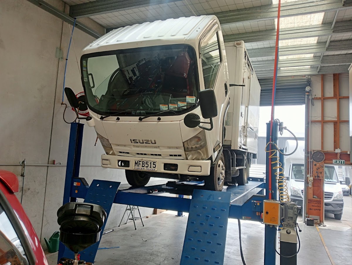 A truck up on the four post hoist inside the workshop